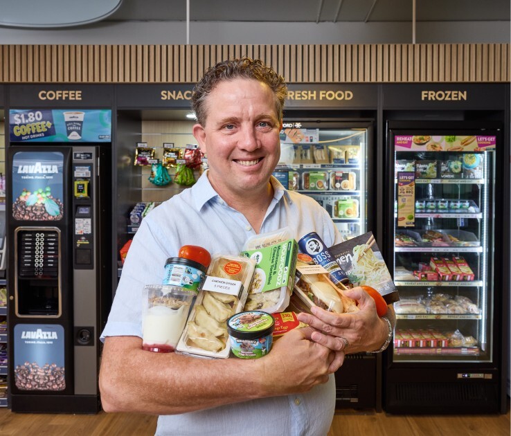 Man holding a bunch of products in front of vending machines